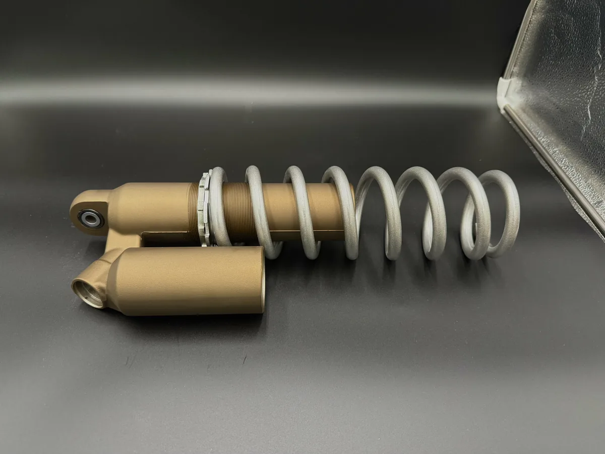 Coated shock and spring assembly on a metal work surface